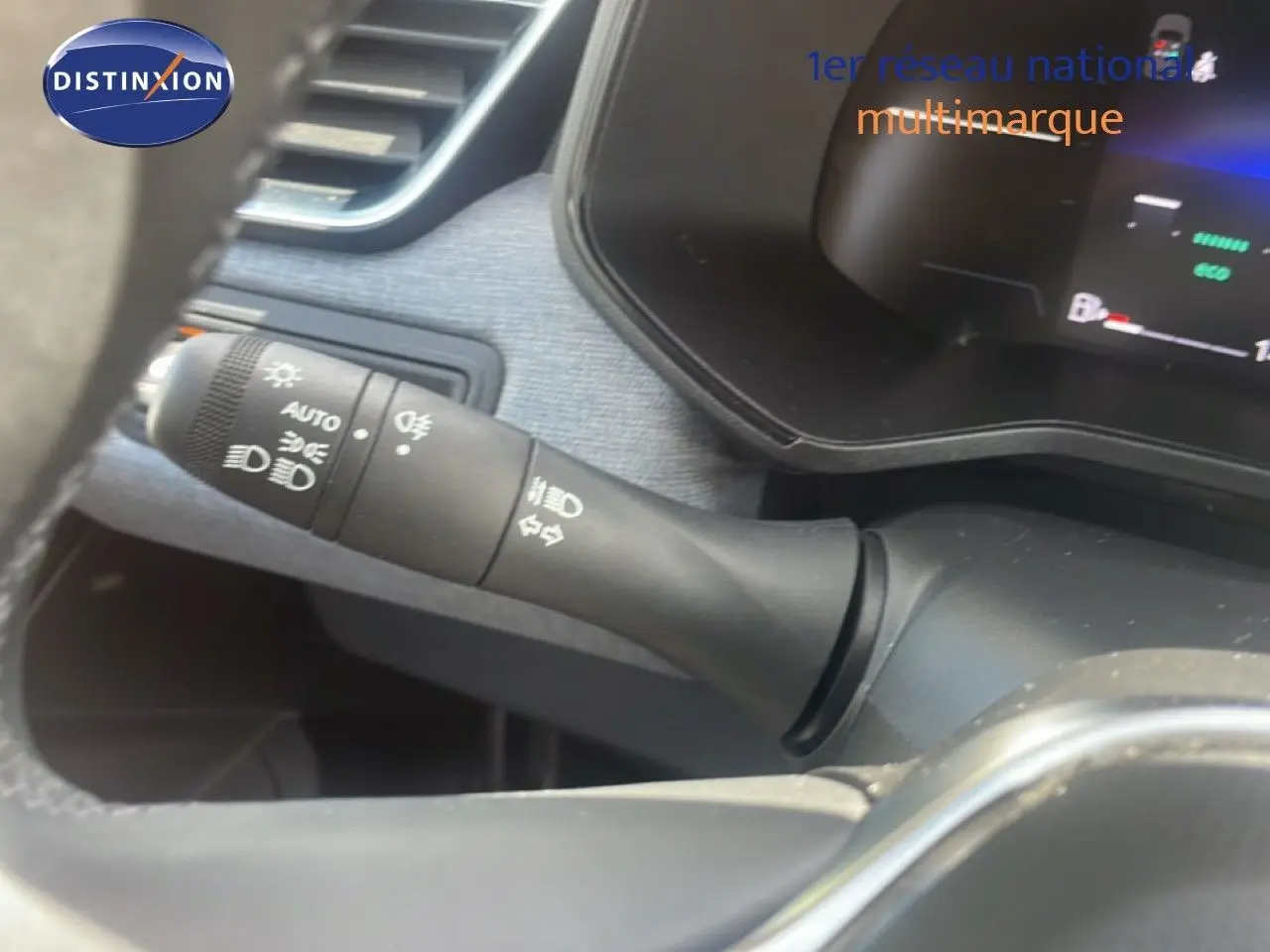 Gros plan sur la commande des feux à gauche du volant dans l’habitacle de la Renault Clio blanche 2025.