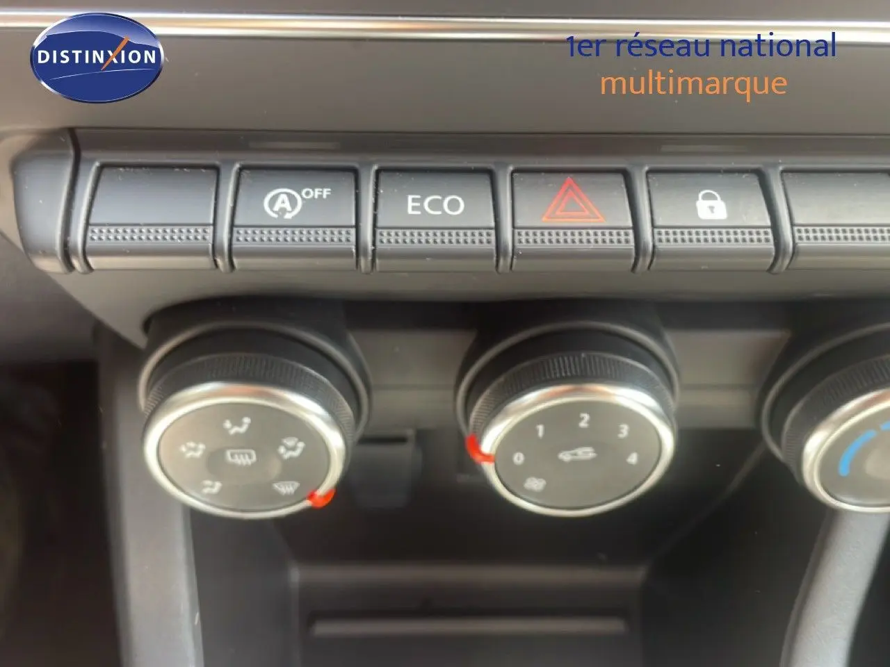 Gros plan sur les commandes de climatisation et boutons fonctionnels du tableau de bord d'une Renault Clio blanche 2025.