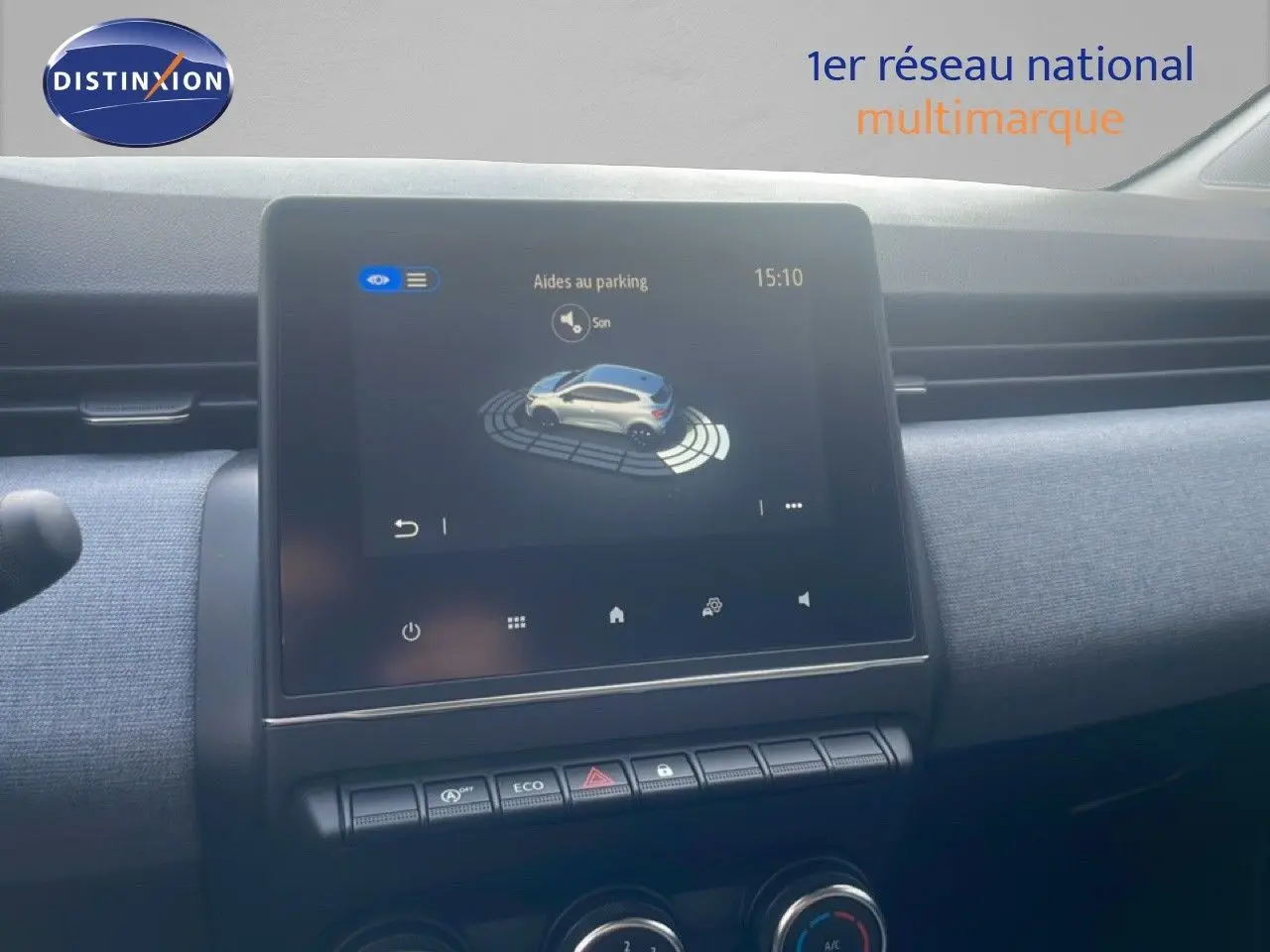 Écran tactile central affichant l'aide au parking dans l'habitacle d'une Renault Clio blanche, vue intérieure frontale.