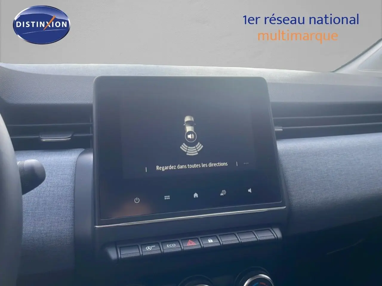 Écran tactile central du tableau de bord de la Renault Clio blanche 2025, avec commandes et finition tissu gris.