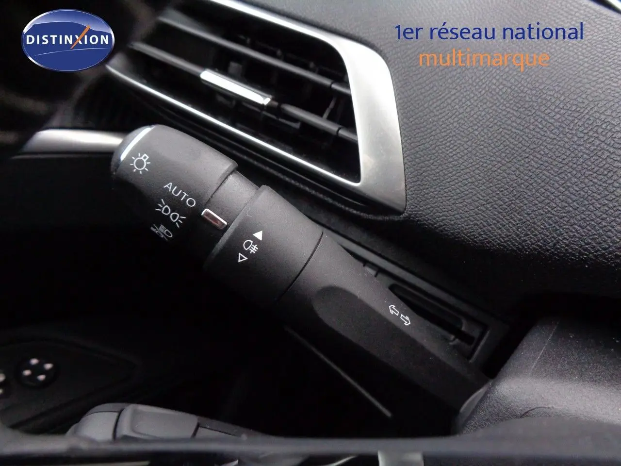 Gros plan sur la commande des feux et clignotants à gauche du tableau de bord noir du Peugeot 3008 gris Artense 2023.