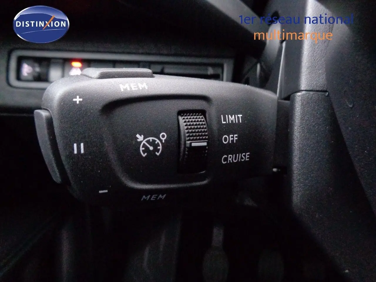 Commande de régulateur de vitesse sur le volant d'un Peugeot 3008 gris Artense 2023, vue intérieure rapprochée.