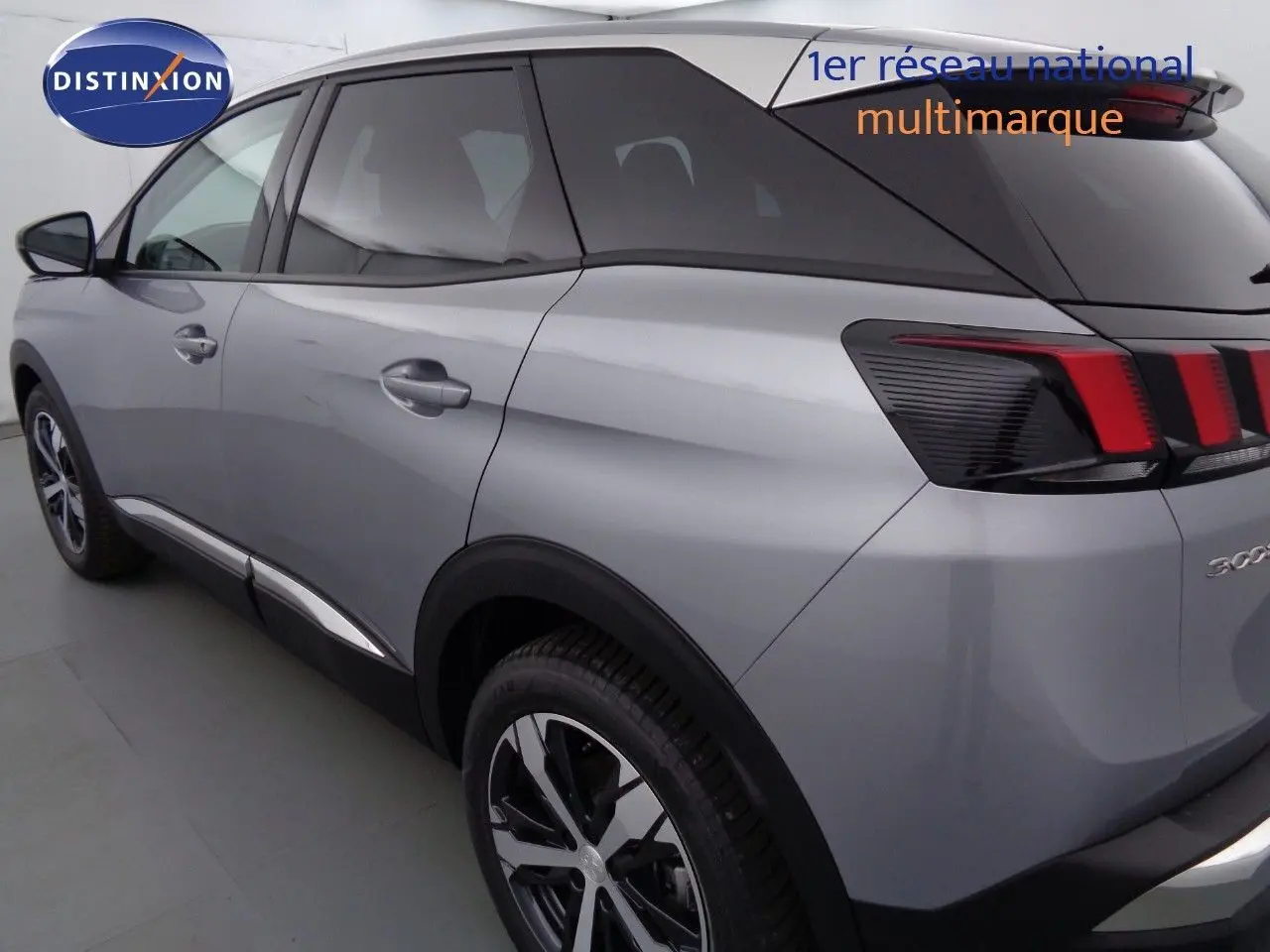Vue 3/4 arrière côté gauche d'un Peugeot 3008 gris Artense métal avec feux arrière à bandes rouges distinctives.