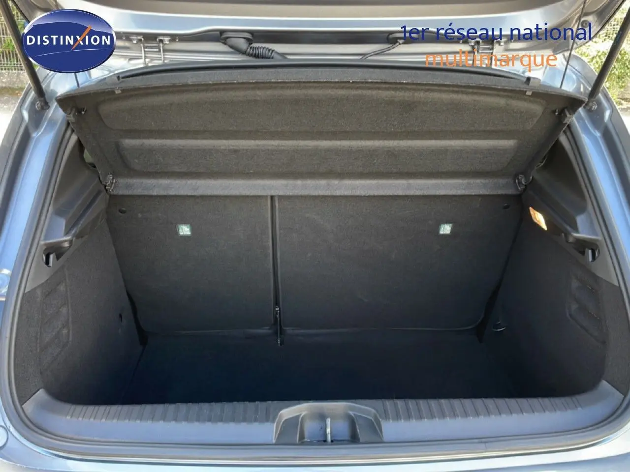 Coffre ouvert de la Renault Clio V 1.0 TCE 90CH CVT Evolution 2025 en gris schiste métal, vue arrière intérieure.