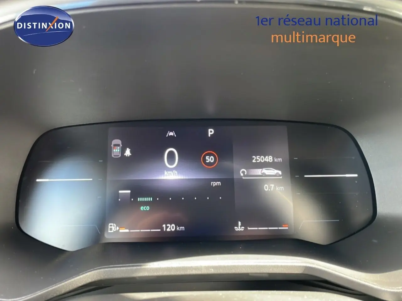 Tableau de bord numérique de Renault Clio 2025 affichant vitesse, kilométrage et autonomie, vue frontale rapprochée.