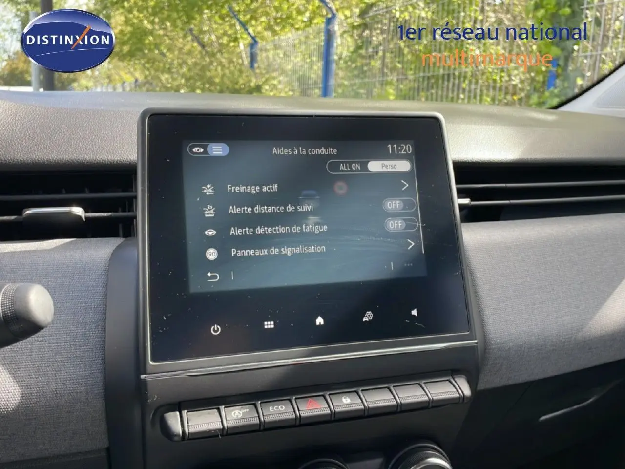 Vue rapprochée de l’écran tactile central du tableau de bord de la Renault Clio gris schiste, affichant les aides à la conduite.