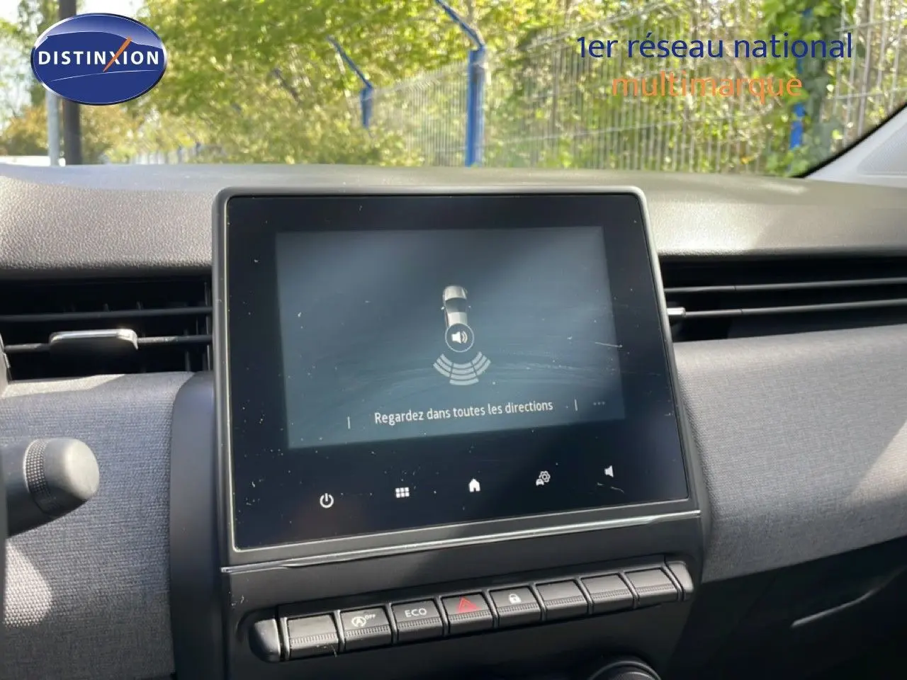 Tableau de bord de Renault Clio 2025, écran tactile central affichant une alerte de sécurité, ambiance intérieure grise.