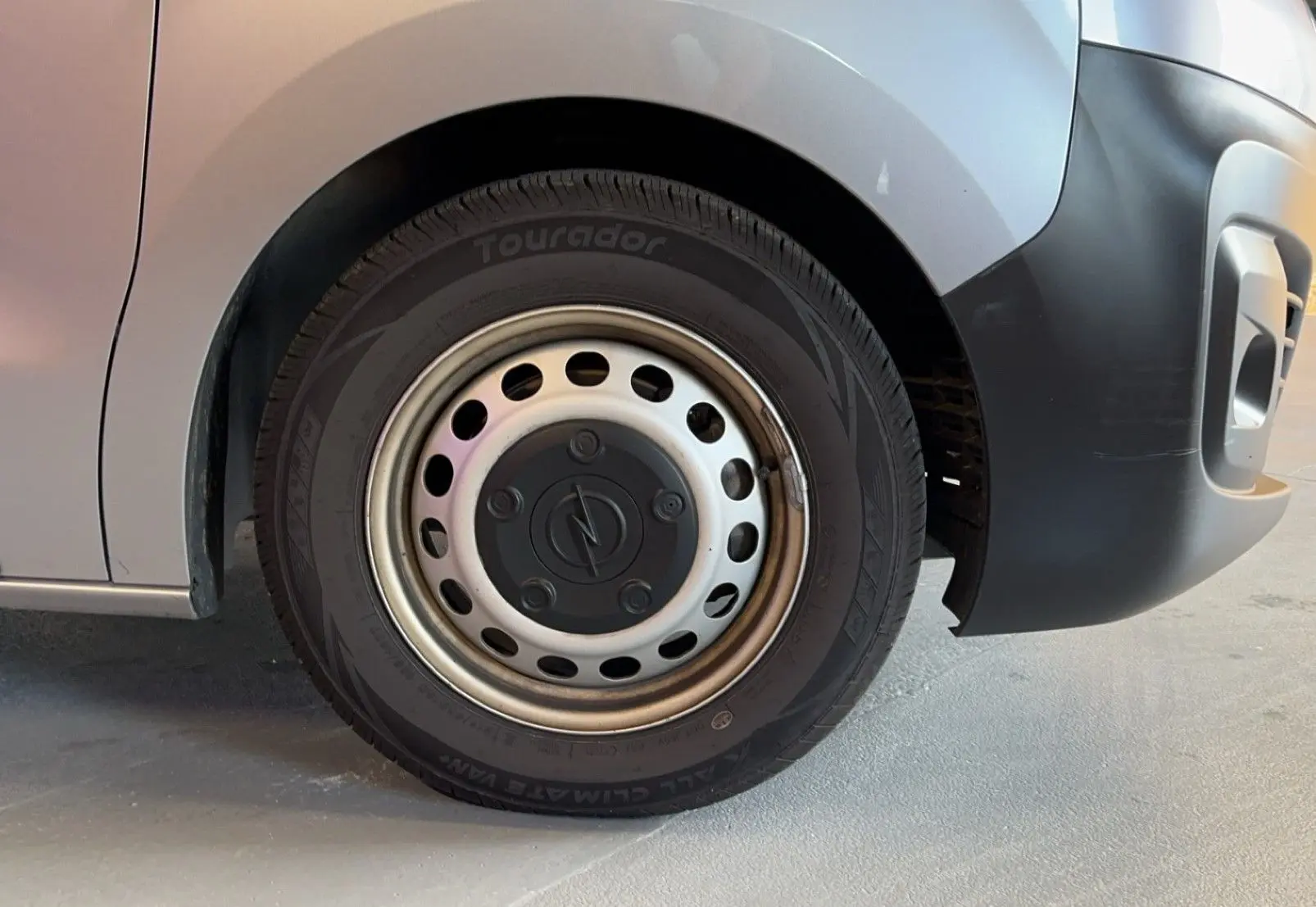 Gros plan sur la roue avant droite grise d'un Opel Vivaro Combi 1.5 Diesel 120 de 2022 avec jante acier.