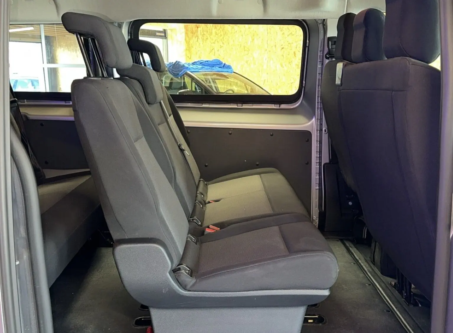 Vue latérale intérieure des sièges en tissu noir du côté gauche de l'Opel Vivaro Combi gris Diesel 2022.