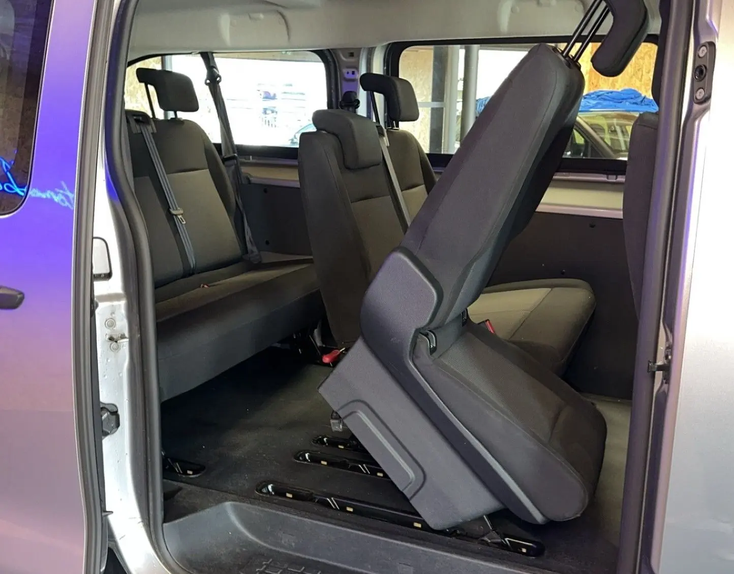 Intérieur du Opel Vivaro Combi gris 2022, vue côté droit sur les sièges en tissu avec un siège relevé au premier plan.