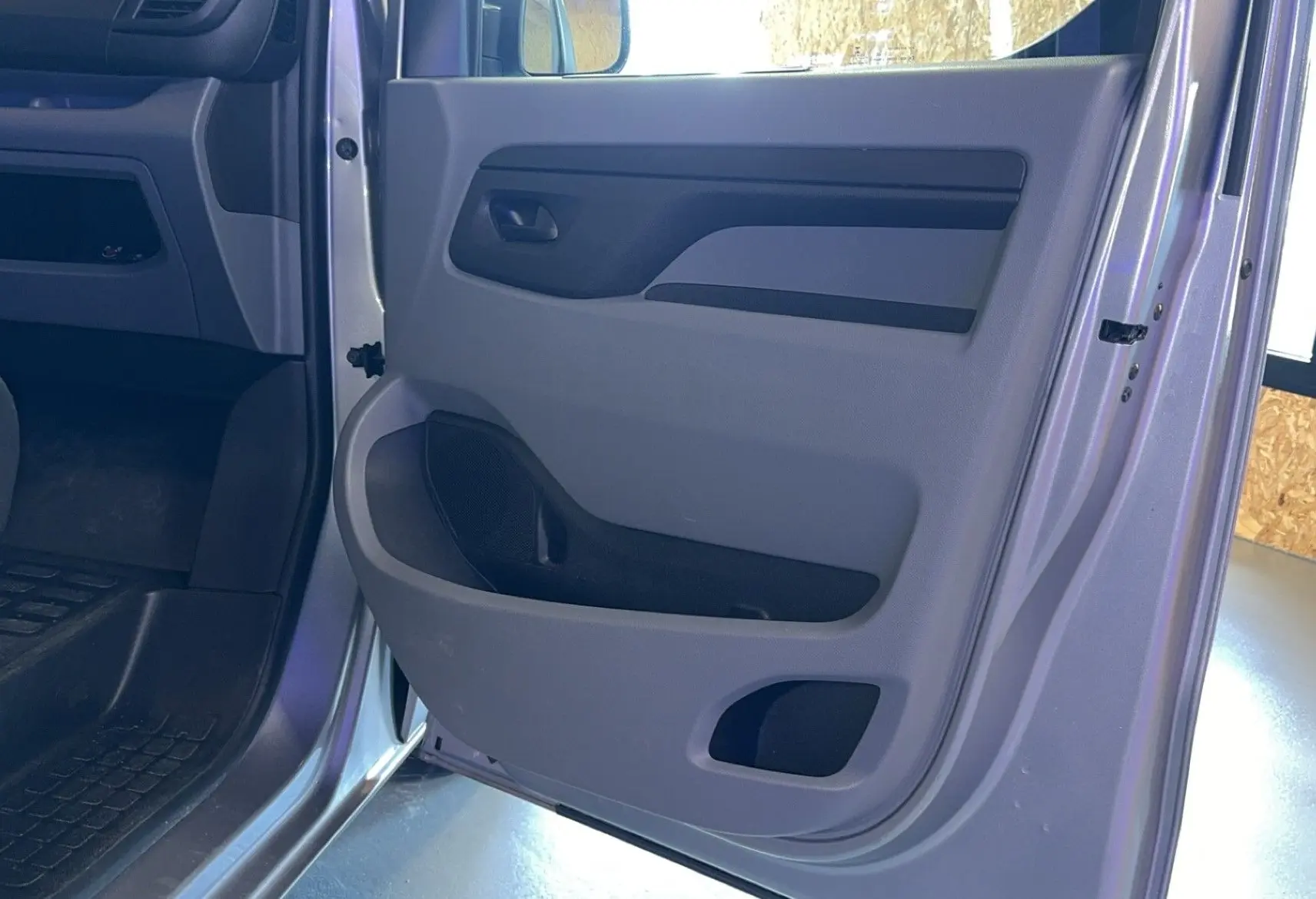 Vue rapprochée de la porte avant droite grise de l'Opel Vivaro Combi 1.5 Diesel 120, intérieur en tissu gris.