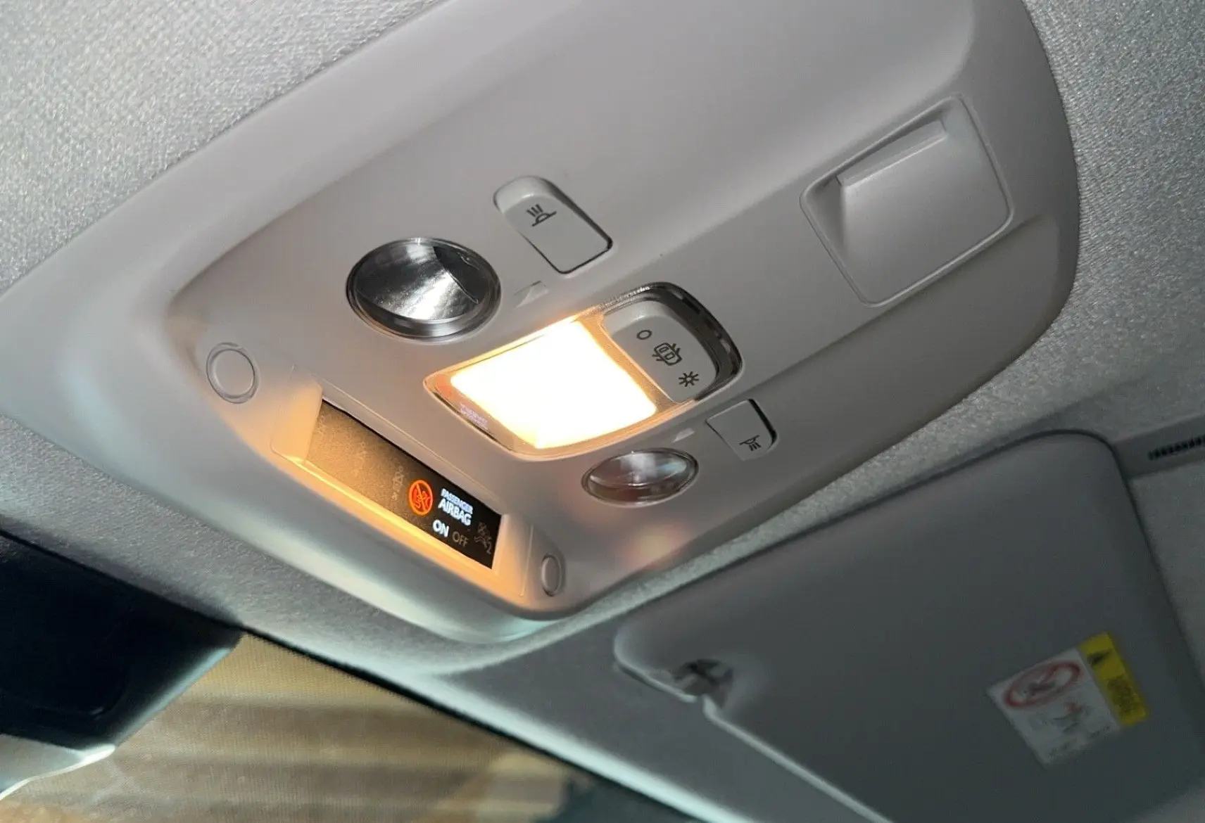 Plafonnier intérieur allumé avec indicateur d'airbag dans un Opel Vivaro Combi gris 2022, vue en légère contre-plongée.