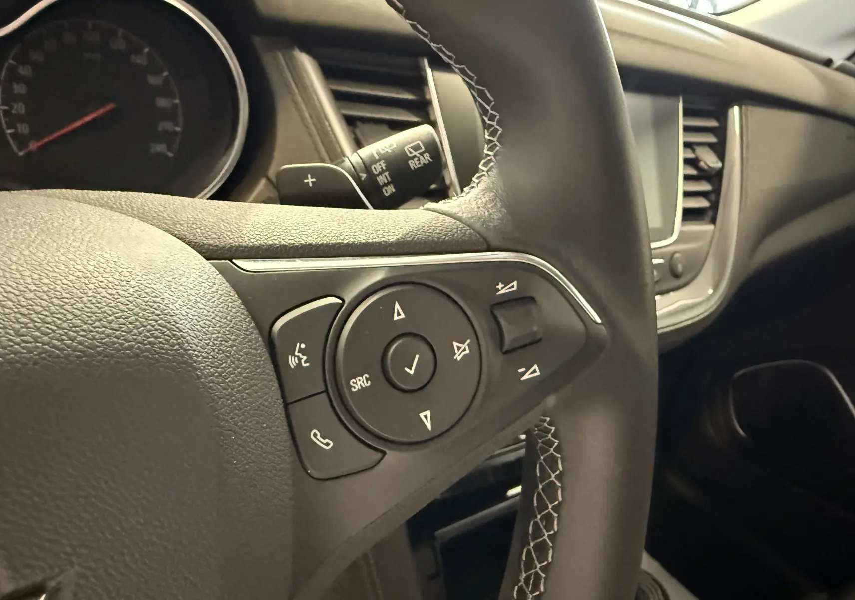 Gros plan sur le volant noir de l’Opel Grandland X 2021, mettant en valeur les commandes audio et téléphone intégrées.
