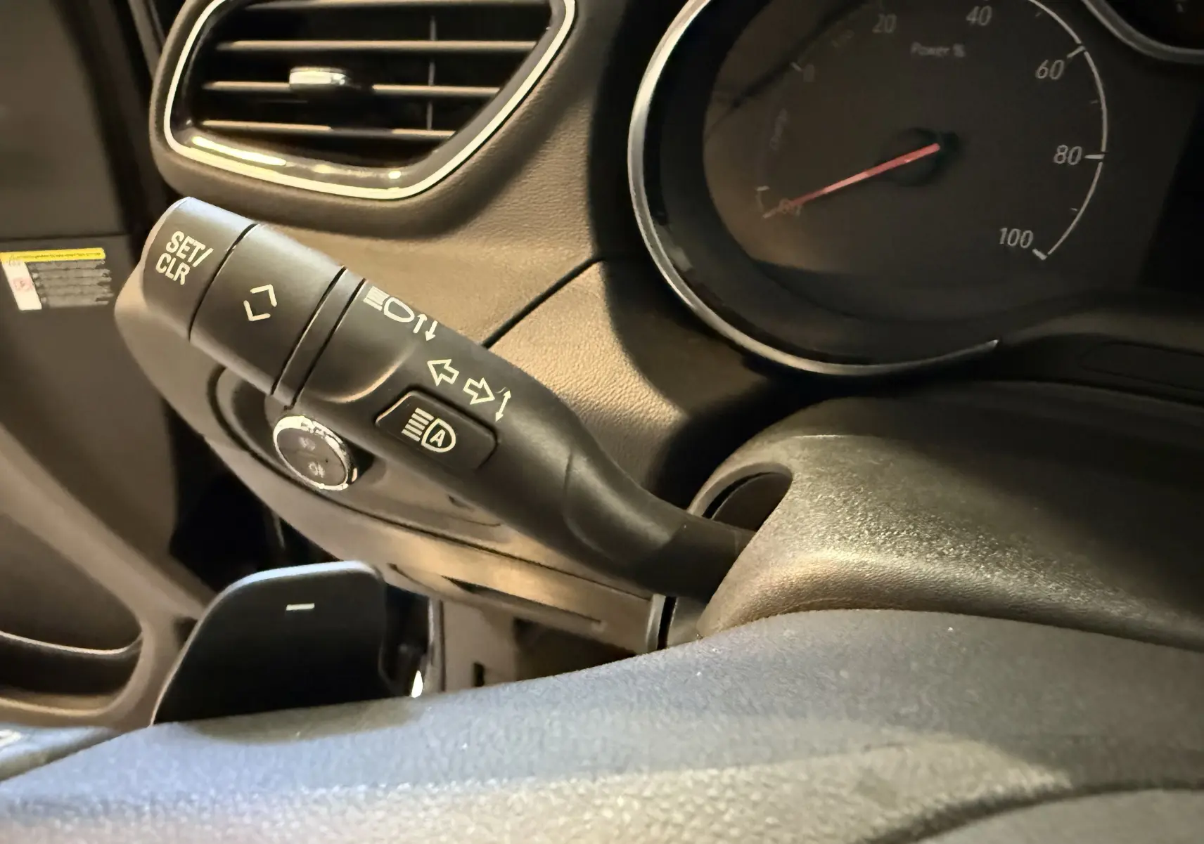 Gros plan sur la commande de clignotant à gauche du volant dans l'habitacle noir de l'Opel Grandland X hybride 2021.