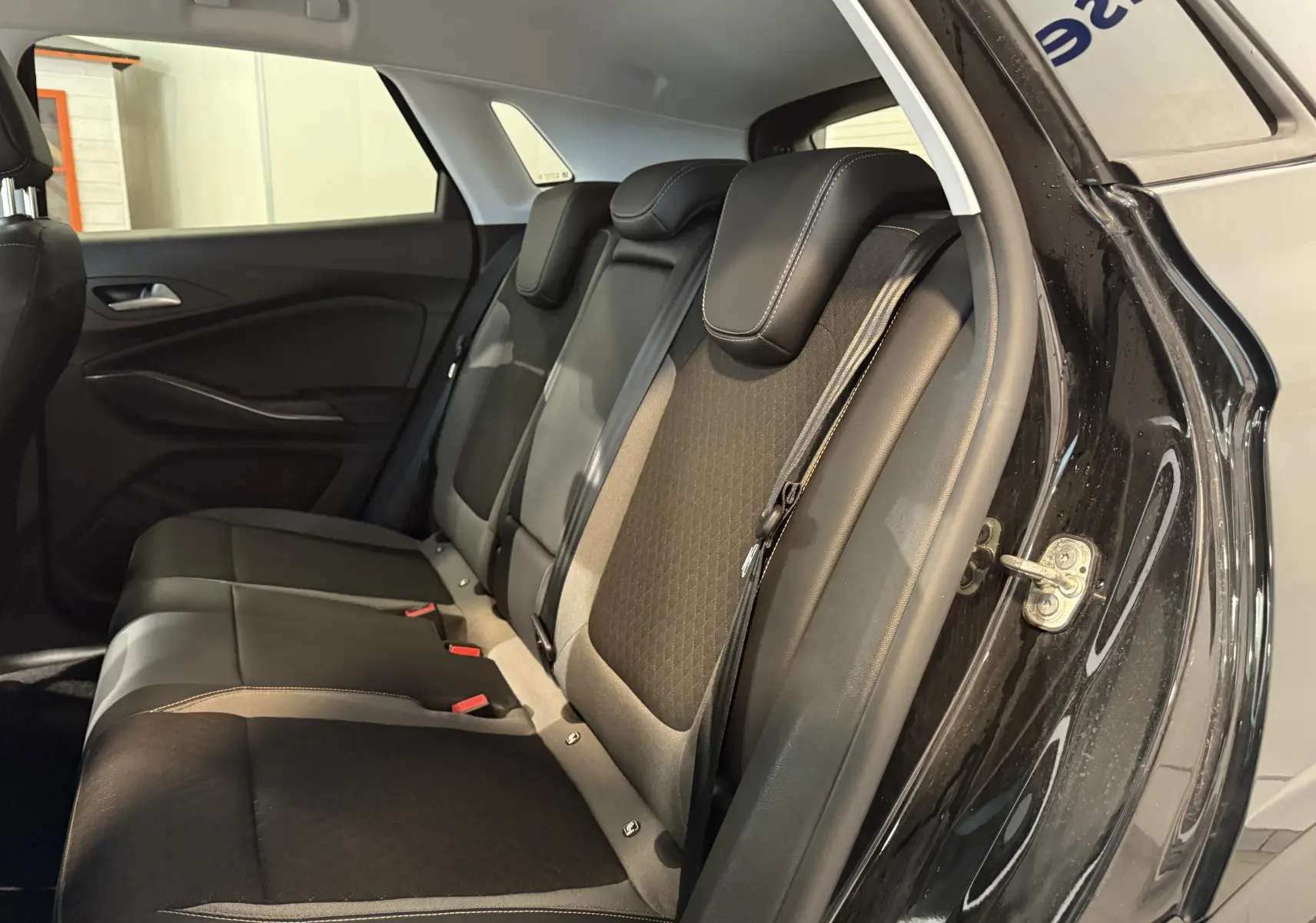 Vue intérieure côté droit des sièges arrière noirs en cuir et tissu de l'Opel Grandland X hybride rechargeable 2021.