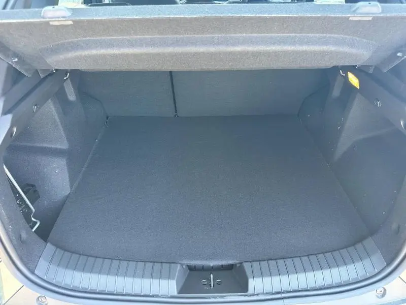 Coffre vide vu de face du Dacia Duster blanc 2025, montrant un espace de chargement propre et bien fini.