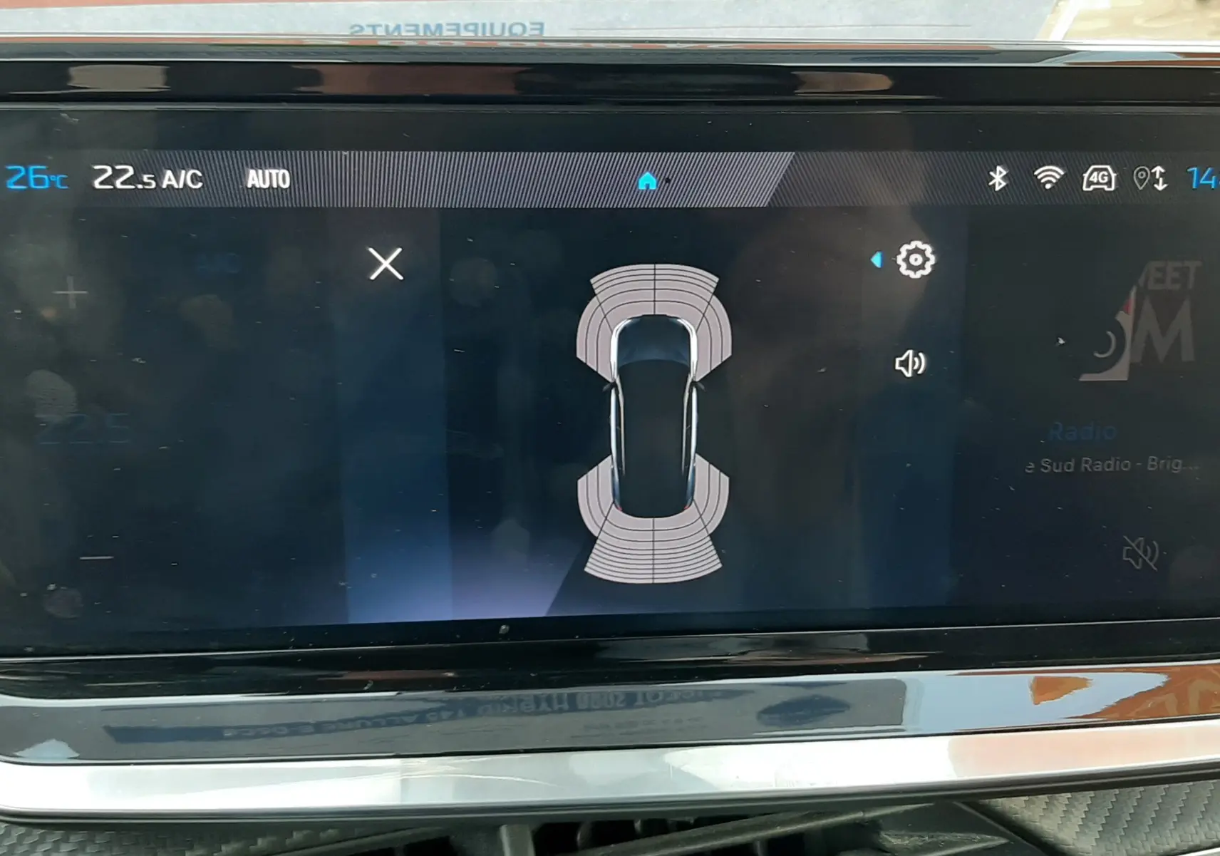 Écran tactile intérieur du Peugeot 2008 Hybrid 145 Allure 2025 montrant l’aide au stationnement et la climatisation.