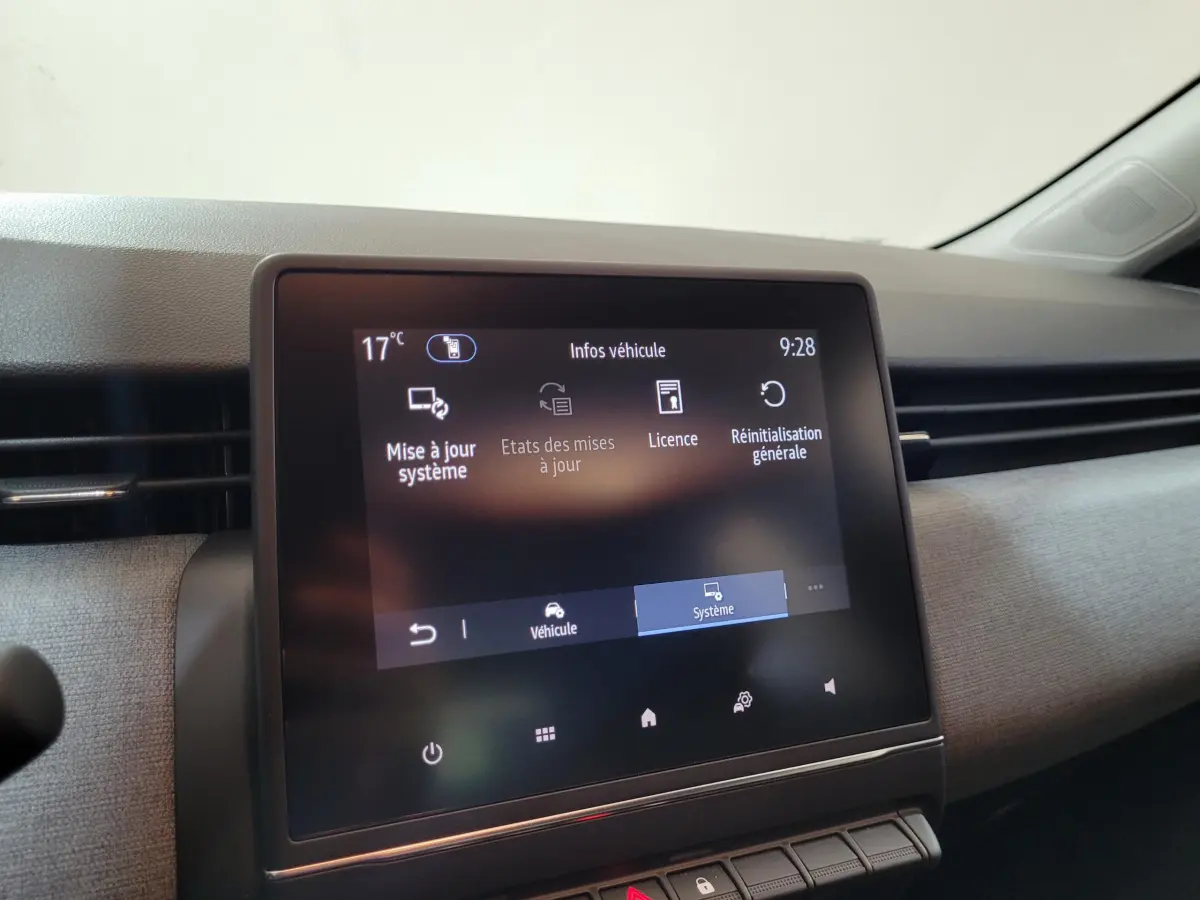 Écran tactile central affichant les options système dans l'habitacle d'une Renault Clio gris foncé, vue de face.
