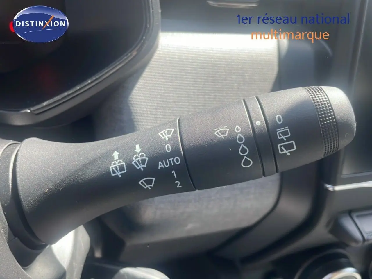 Gros plan sur la commande d'essuie-glace noire dans l'habitacle d'une Renault Clio blanche 2025.