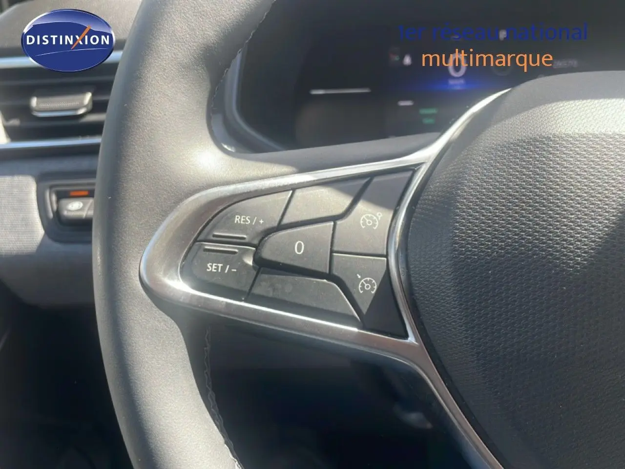 Gros plan sur le volant avec commandes intégrées d'une Renault Clio blanche, version 2025, boîte automatique.