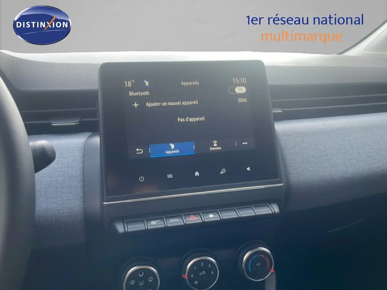 Vue intérieure du tableau de bord de la Renault Clio blanche 2025, avec écran tactile central et commandes de climatisation.