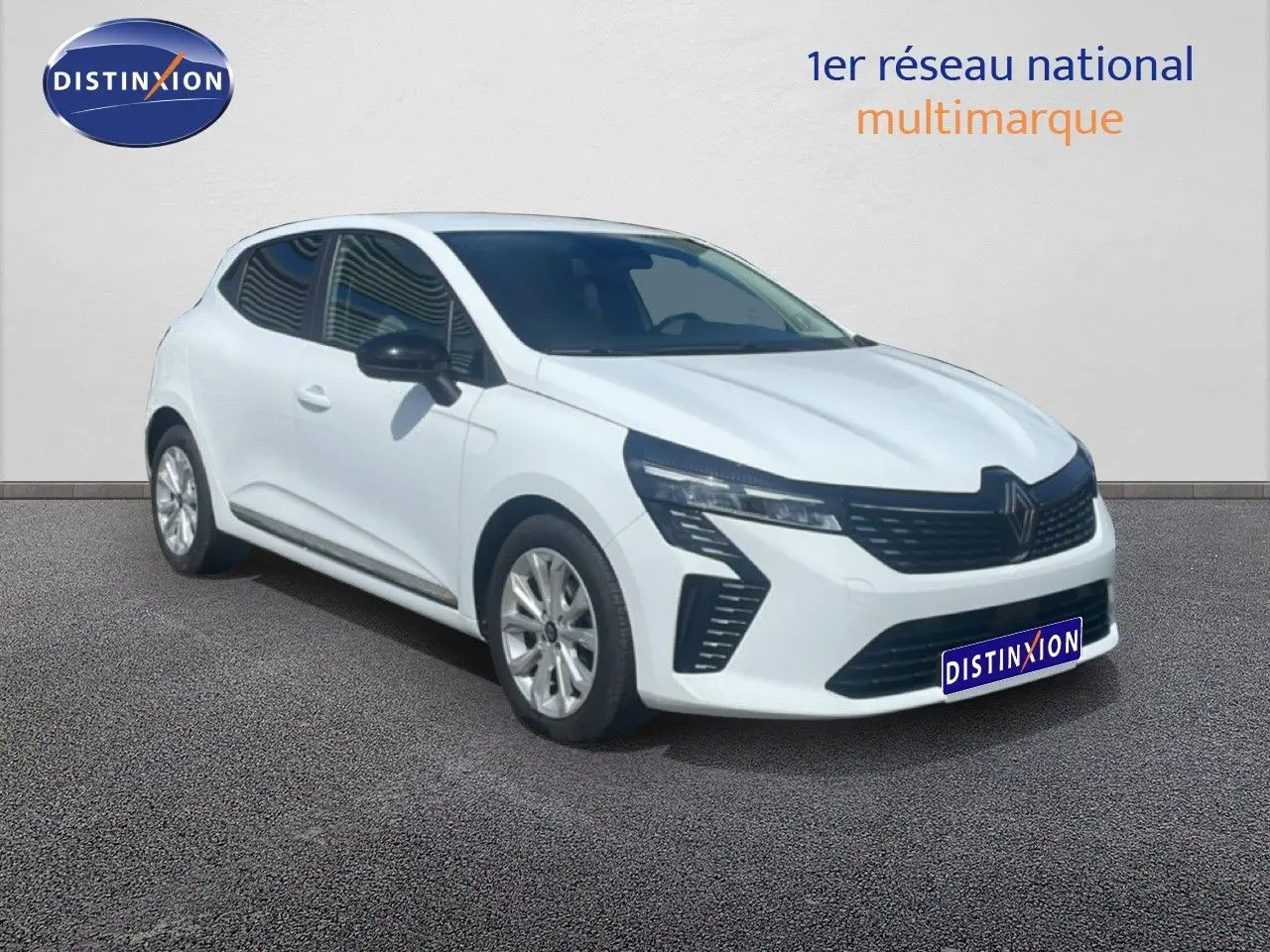 Renault Clio blanche vue 3/4 avant droit, avec calandre noire et jantes alliage argentées.