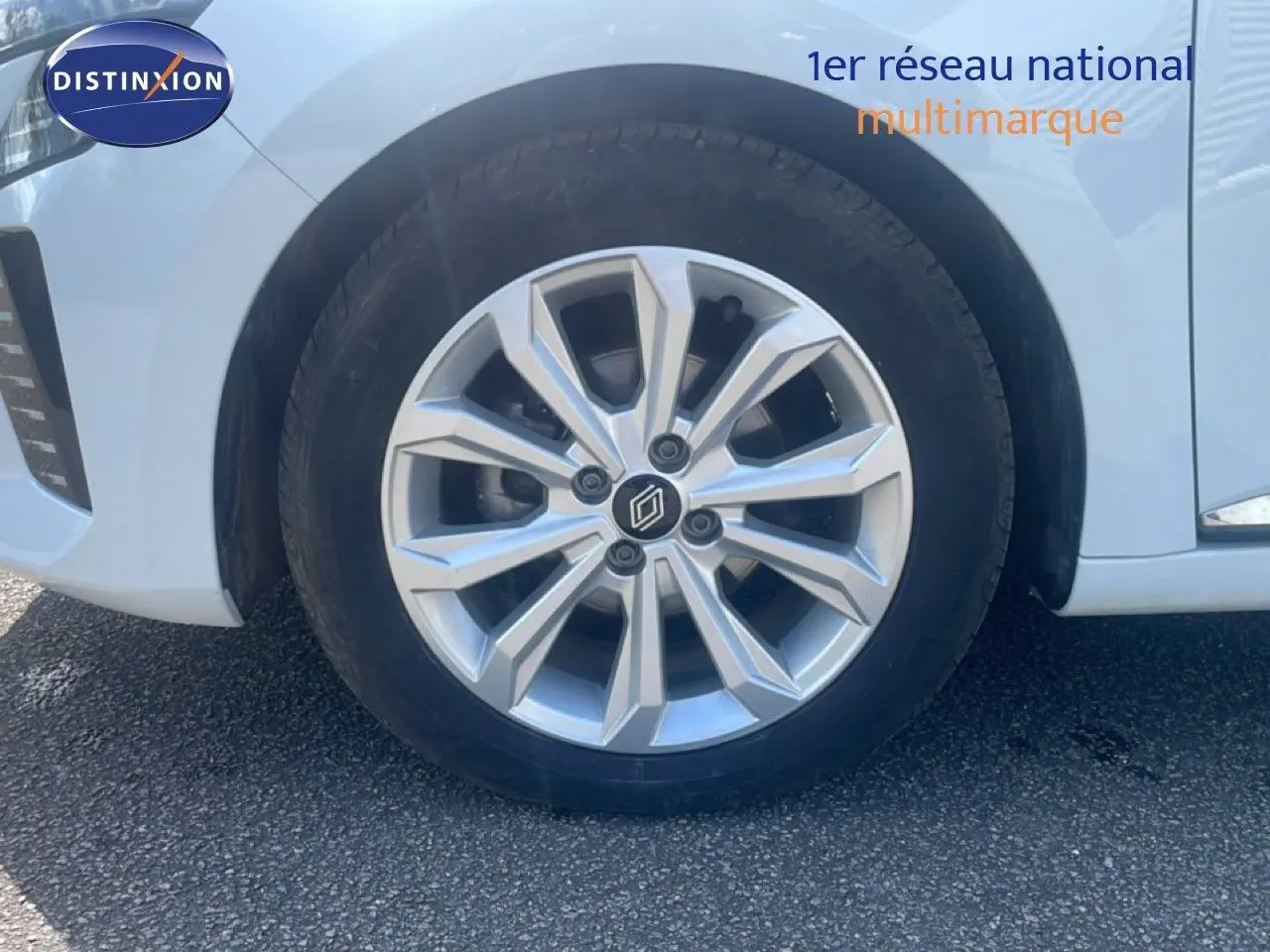 Gros plan sur la roue avant droite d’une Renault Clio blanche 2025 avec jante alliage argentée au design moderne.