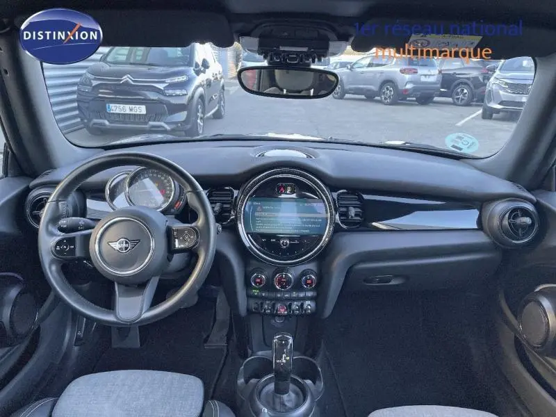 Intérieur noir de la MINI Cabriolet Cooper 2023 vu de face, avec volant cuir multifonction et écran tactile central.