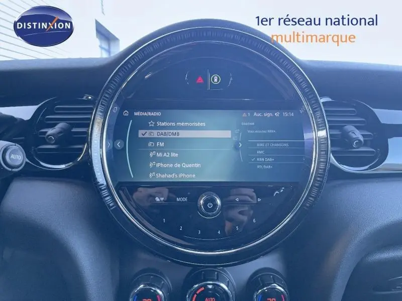 Tableau de bord de MINI Cabriolet Cooper 2023, écran tactile central rond affichant menu radio, finition noire Midnight Black II.