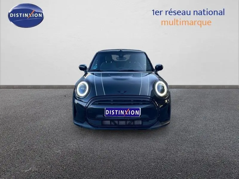 Vue frontale d'une MINI Cabriolet Cooper 2023 en Midnight Black II avec phares LED circulaires allumés.