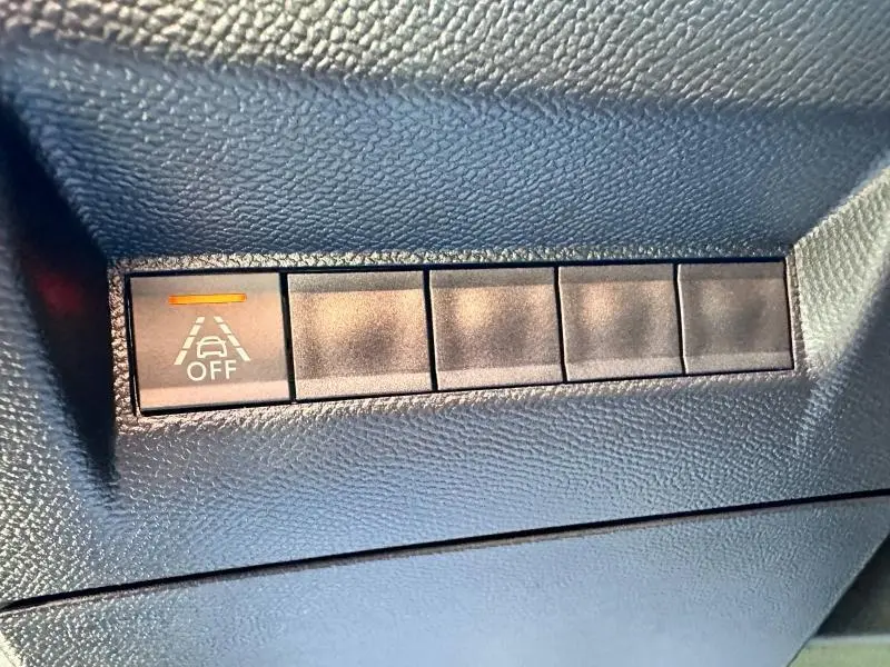 Bouton de désactivation de l'alerte de franchissement de ligne sur tableau de bord noir d'une Peugeot 2008 gris Artense.