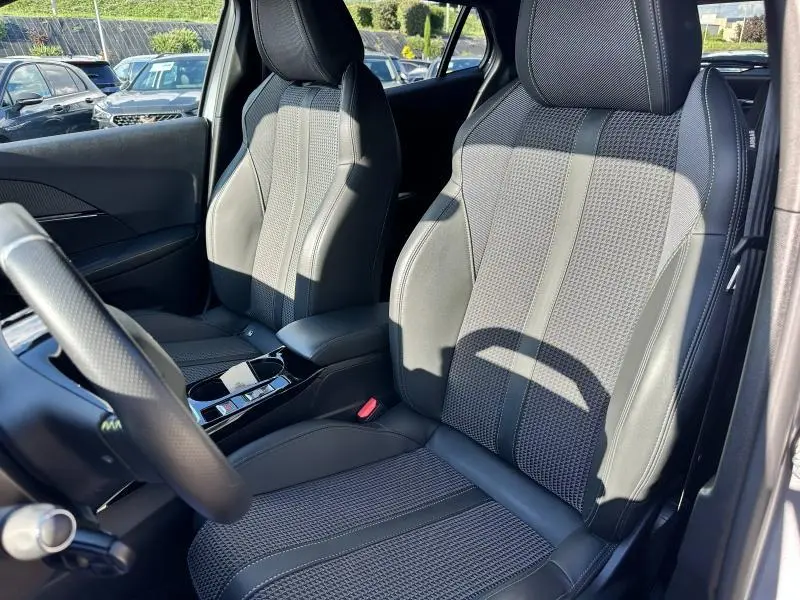 Vue intérieure des sièges avant en tissu tri-matières du Peugeot 2008 GT gris Artense, avec volant multifonction partiellement visible.