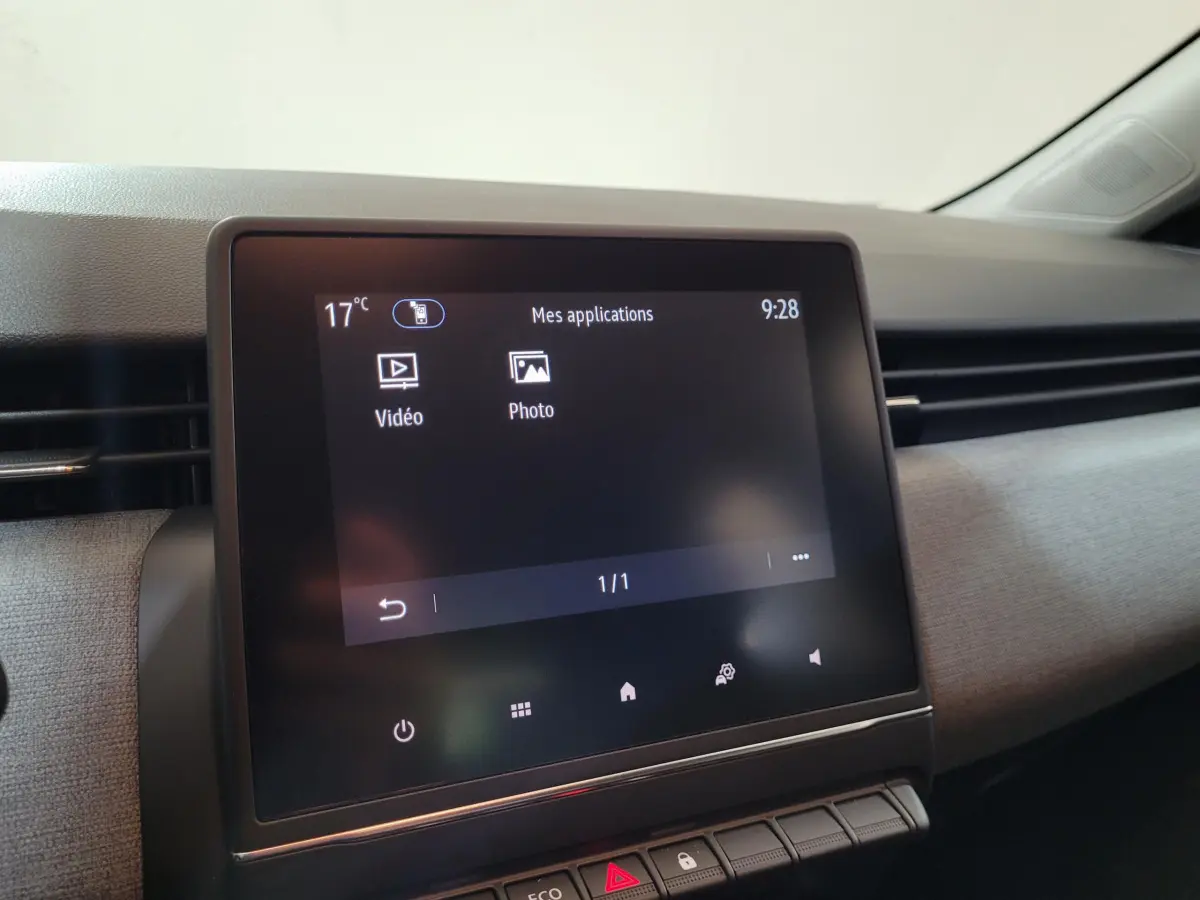 Écran tactile central affichant les applications vidéo et photo dans l’habitacle gris clair de la Renault Clio Evolution Blue dCi 100.