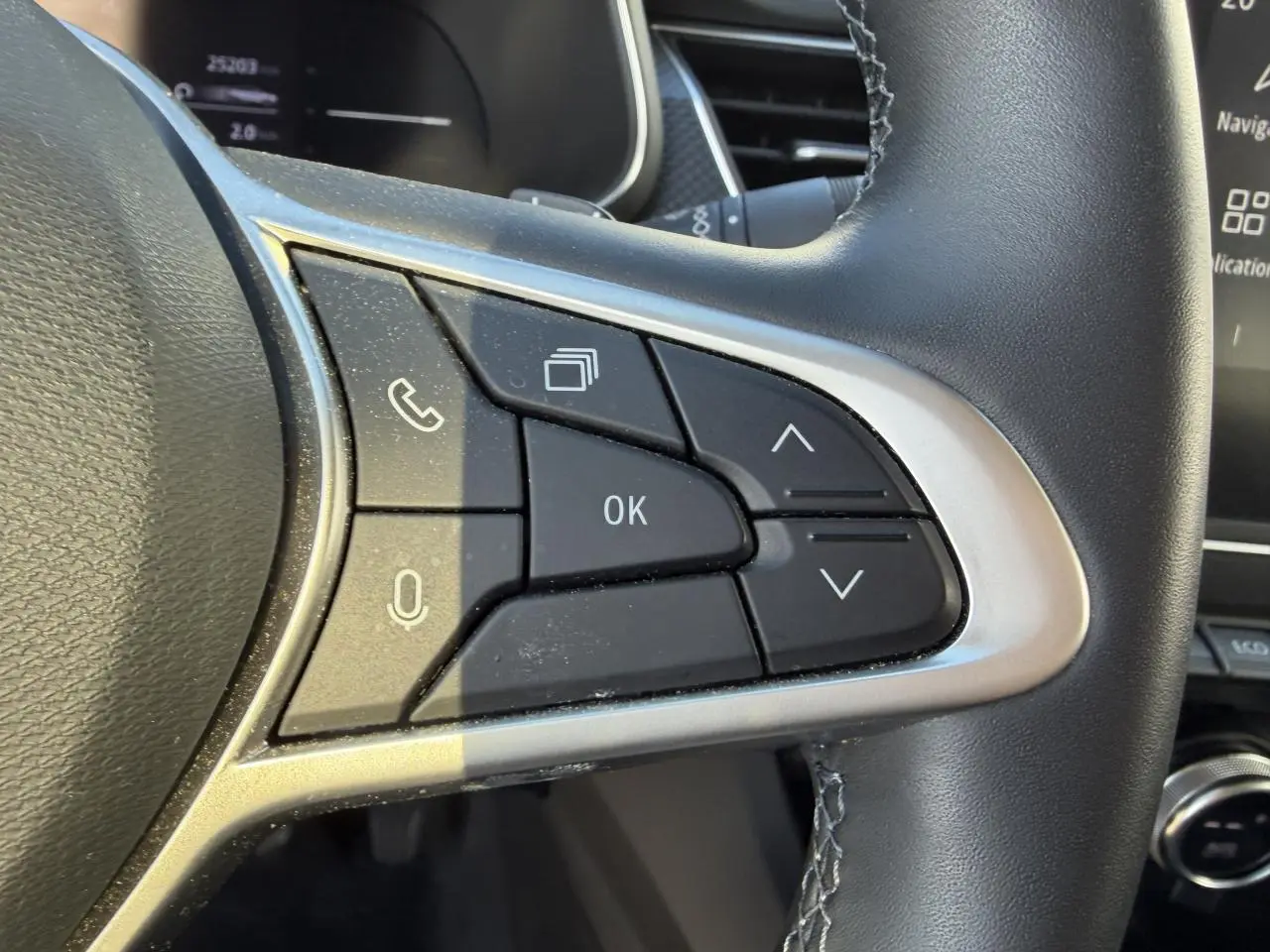 Gros plan sur les commandes au volant côté droit du Renault Arkana 2025, finition noire avec contour argenté.