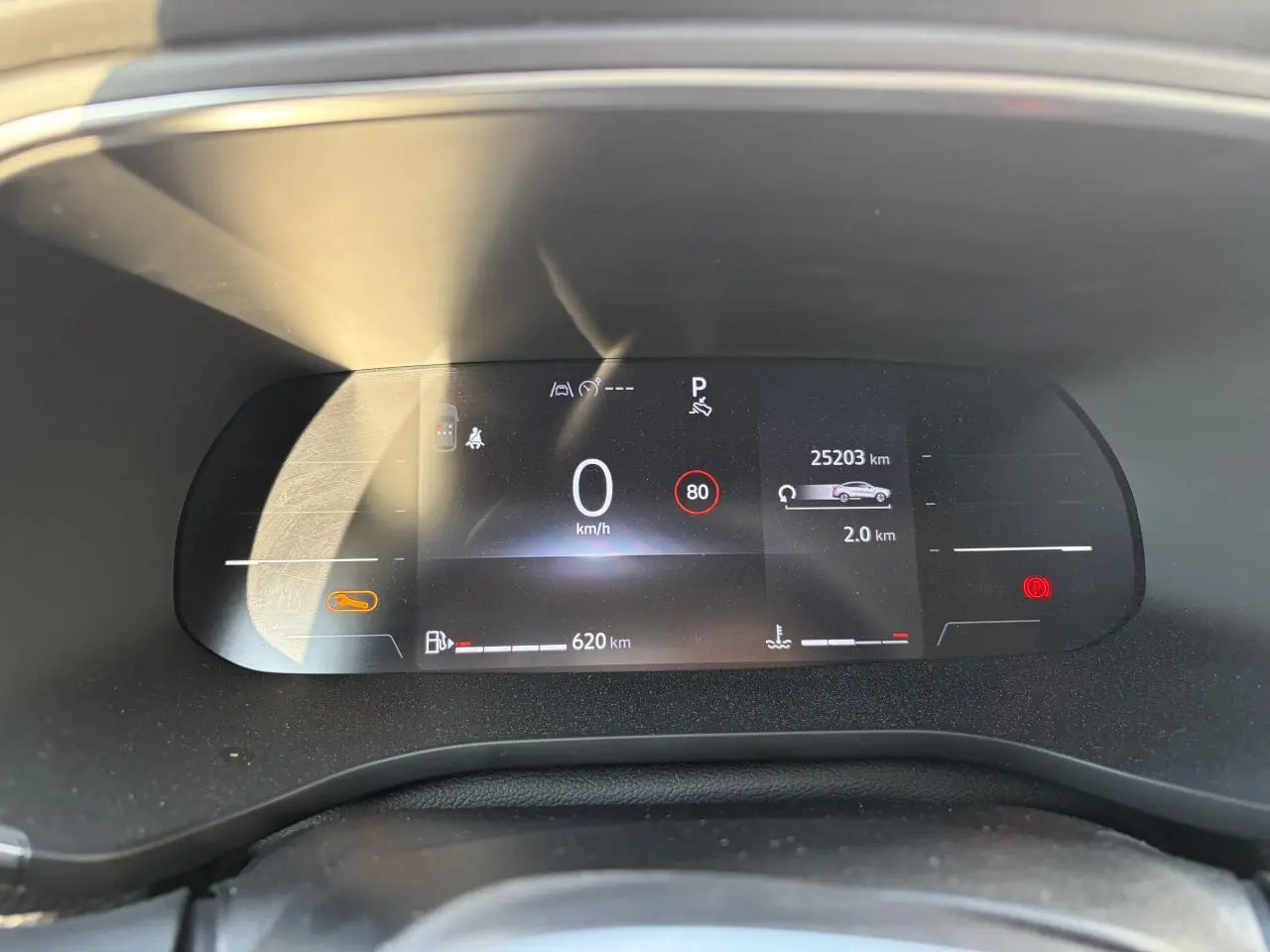 Tableau de bord numérique du Renault Arkana 2025, affichage vitesse, autonomie et alertes, vue de face rapprochée.