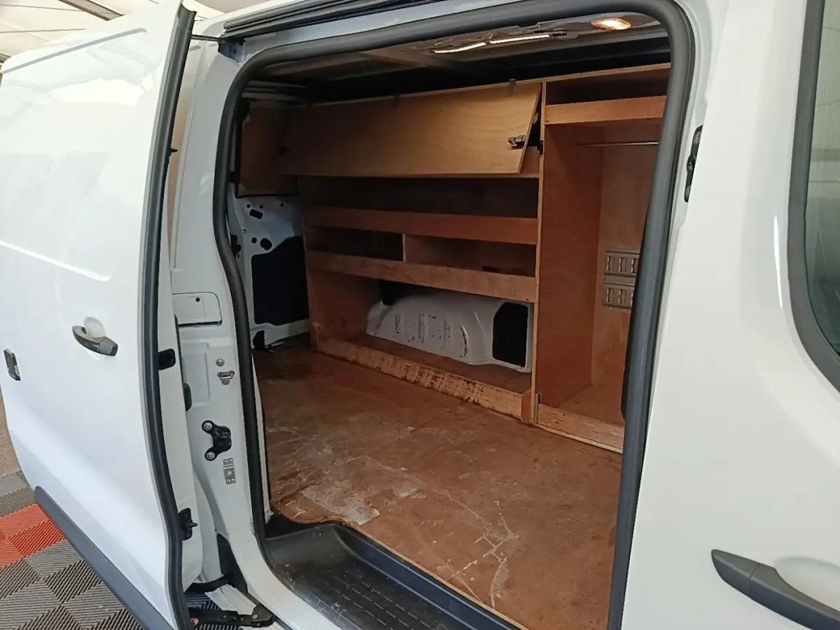 Vue latérale droite d’un Citroën Jumpy blanc 2021 avec porte coulissante ouverte montrant l’aménagement bois intérieur.