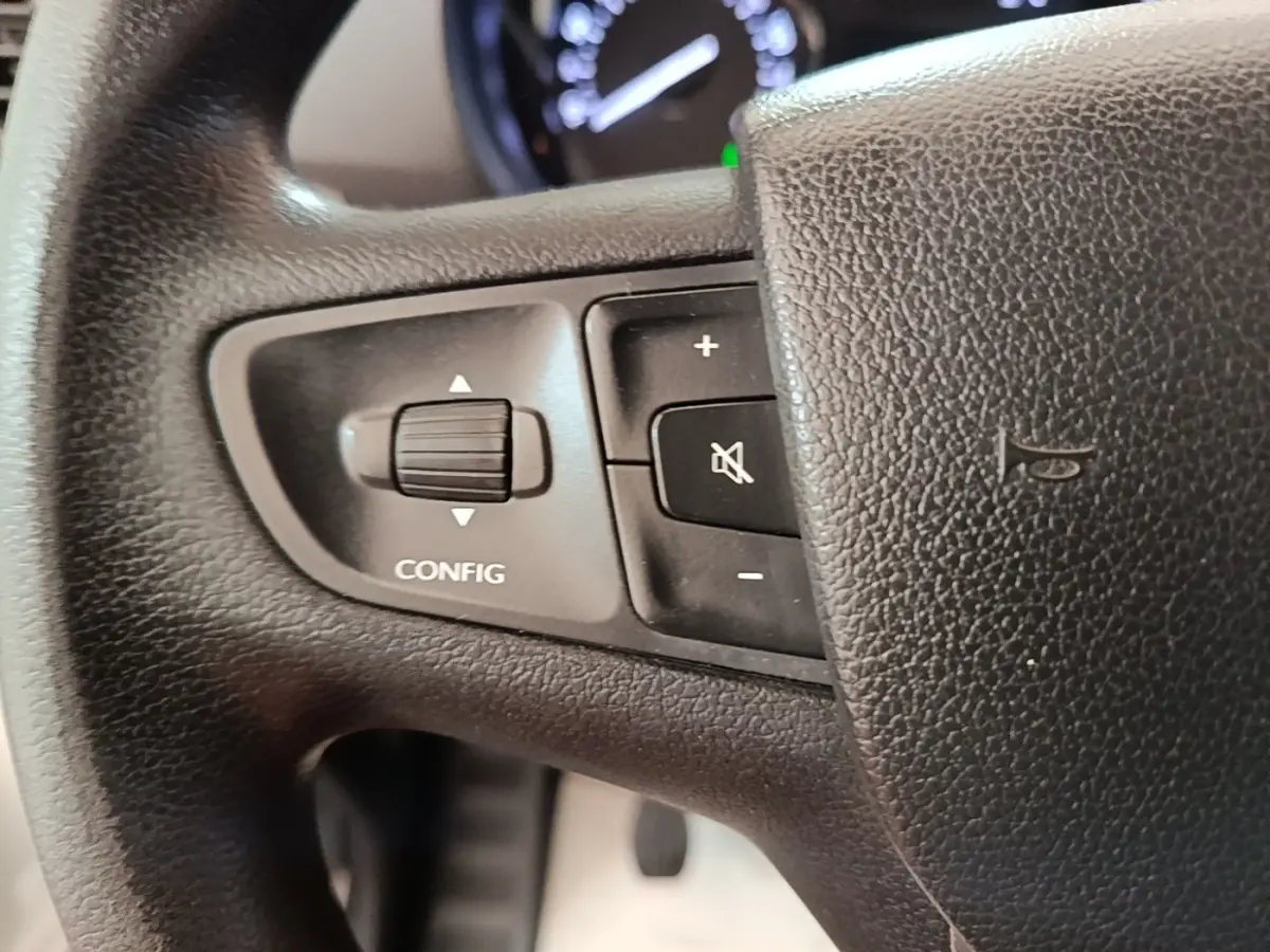 Gros plan sur les commandes gauche du volant noir du Citroën Jumpy XS BlueHDi 120, boutons de réglage et silence.