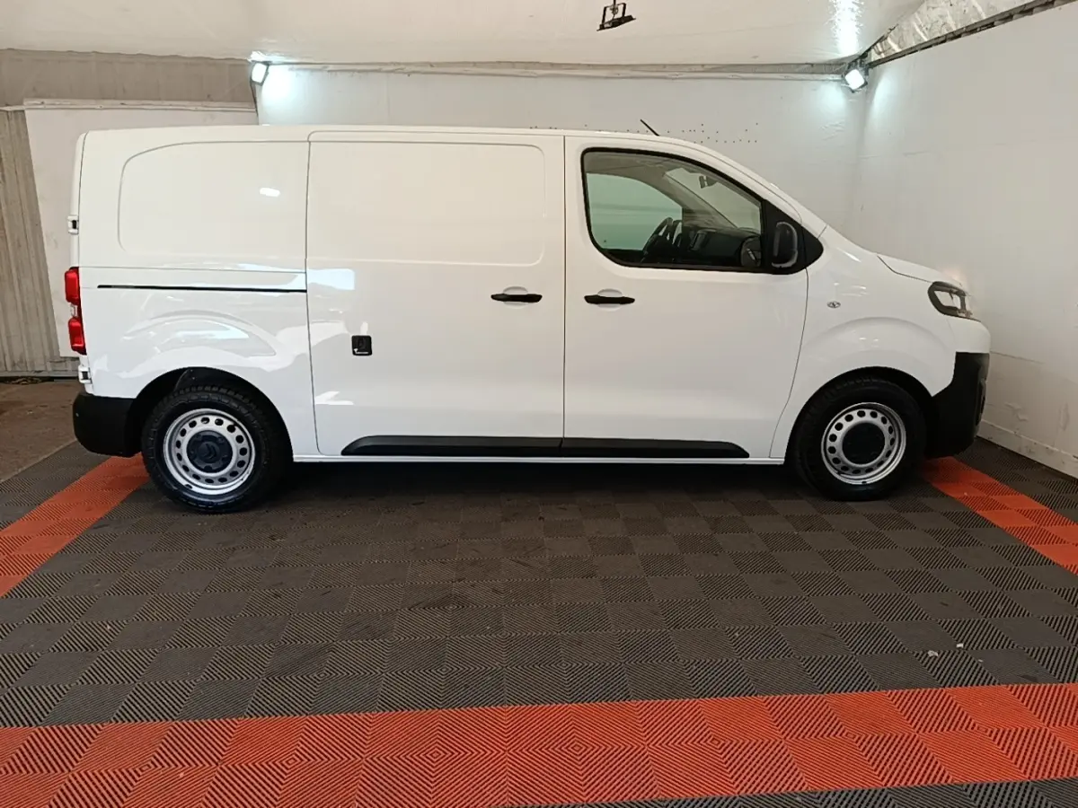 Vue de profil côté gauche d’un Citroën Jumpy blanc utilitaire avec jantes acier et poignées noires.