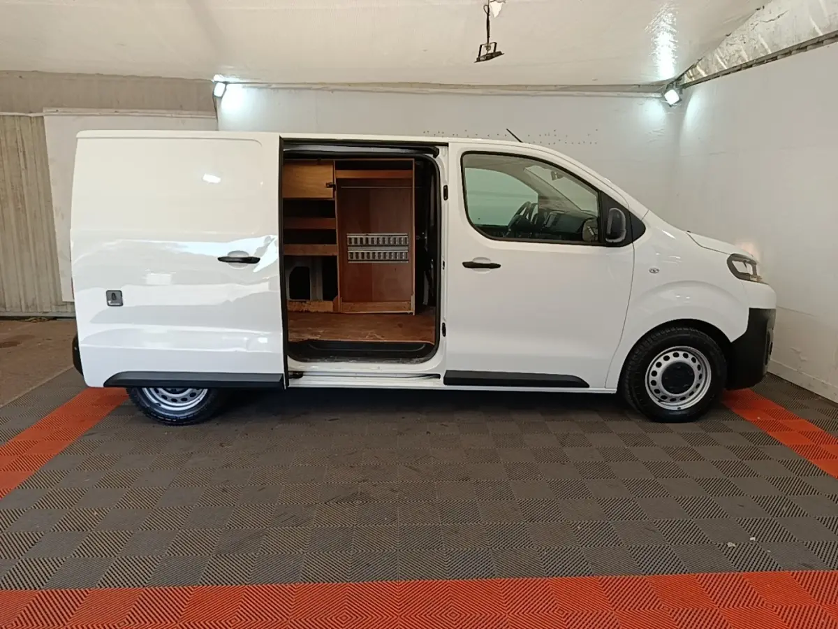 Vue de profil droit d’un Citroën Jumpy blanc 2021 avec porte latérale coulissante ouverte montrant l’aménagement intérieur en bois.