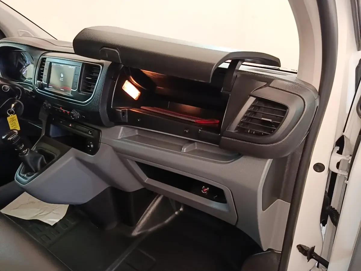 Intérieur du Citroën Jumpy XS 2021 blanc, vue côté passager avec boîte manuelle et boîte à gants ouverte éclairée.