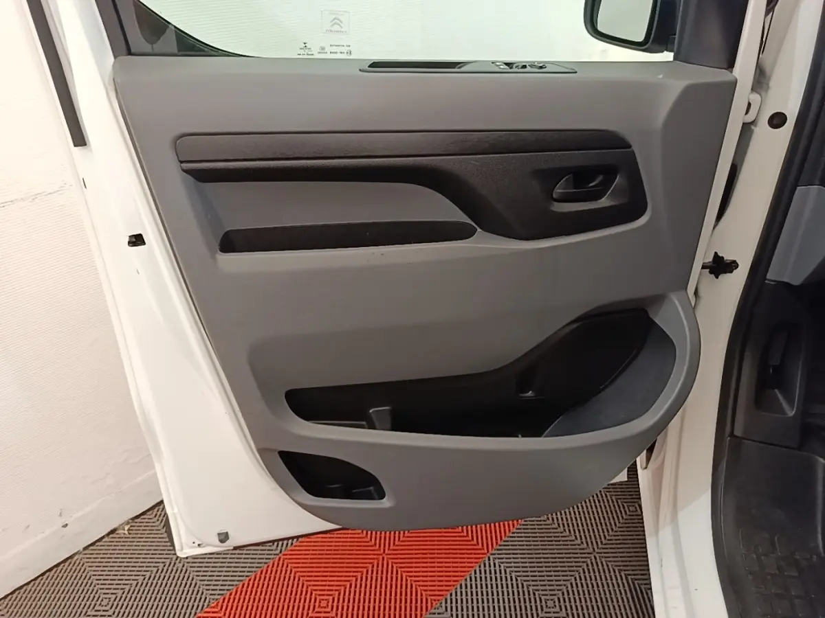 Vue rapprochée de la porte avant gauche blanche du Citroën Jumpy XS BlueHDi 120, avec panneau intérieur gris et noir.