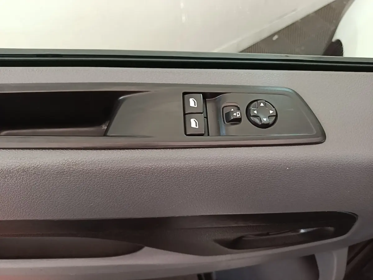 Détail de la commande des rétroviseurs électriques sur la porte intérieure grise du Citroën Jumpy blanc.