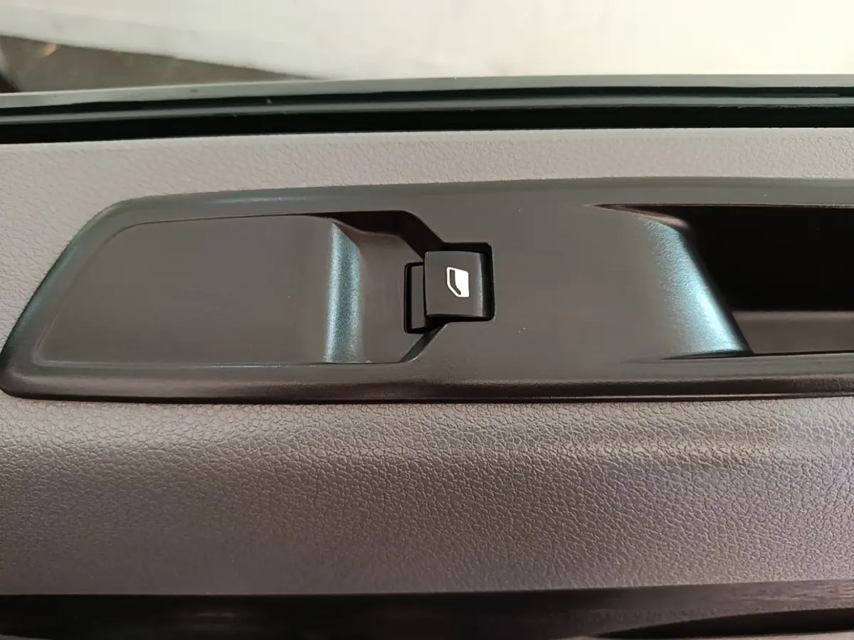 Détail de la commande de vitre électrique intérieure noire sur porte d’un Citroën Jumpy blanc 2021.
