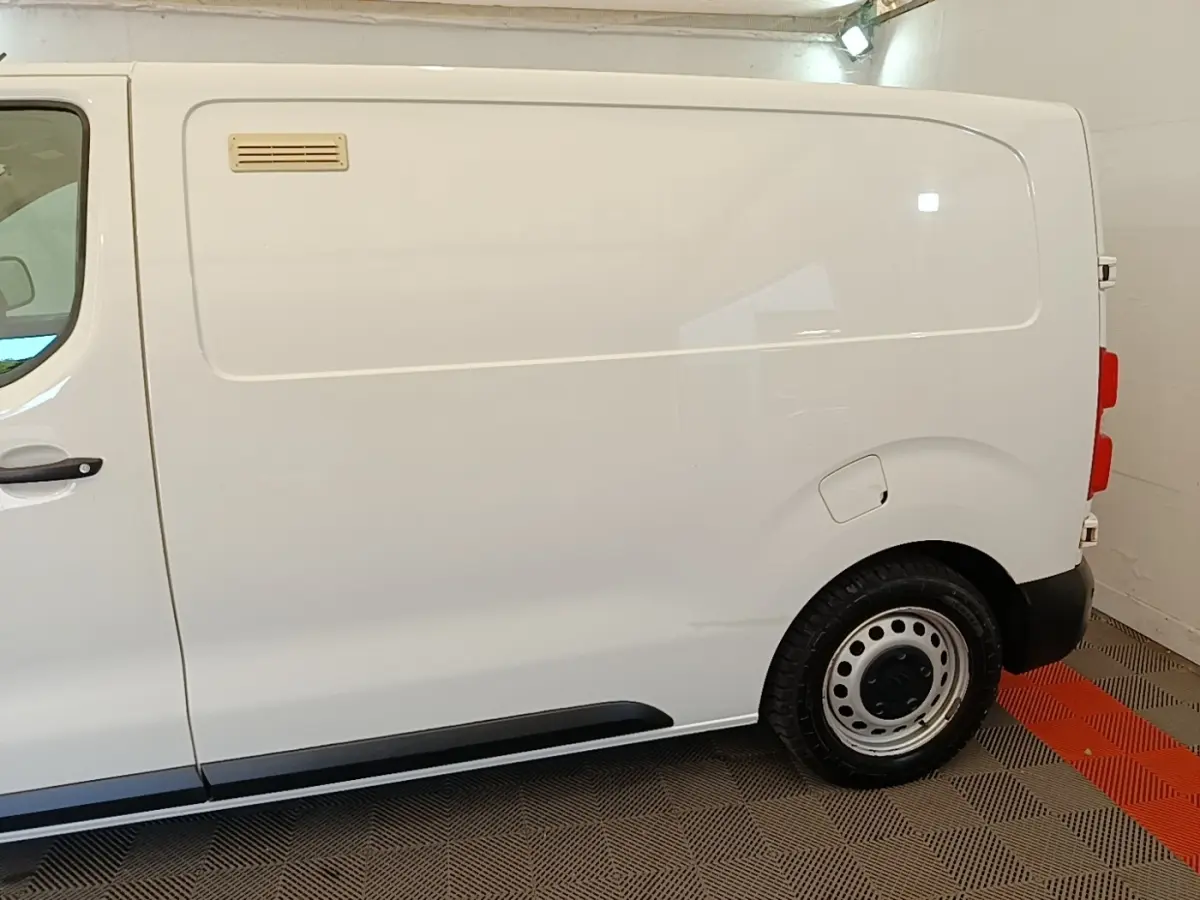 Vue latérale droite d’un utilitaire Citroën Jumpy XS BlueHDi 120 blanc, sans fenêtres latérales, avec jante acier.