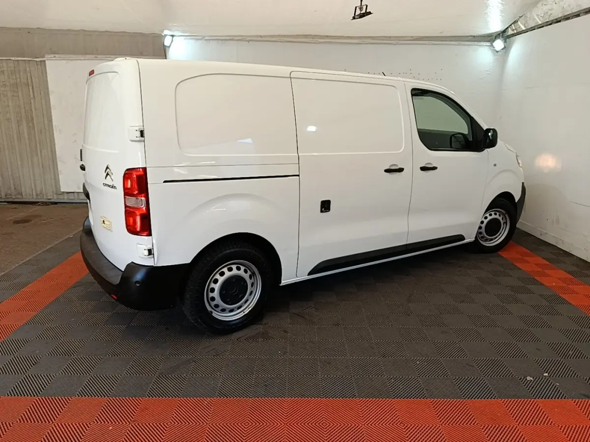 Vue 3/4 arrière côté droit d’un Citroën Jumpy blanc 2021, fourgon utilitaire avec roues acier et pare-chocs noirs.