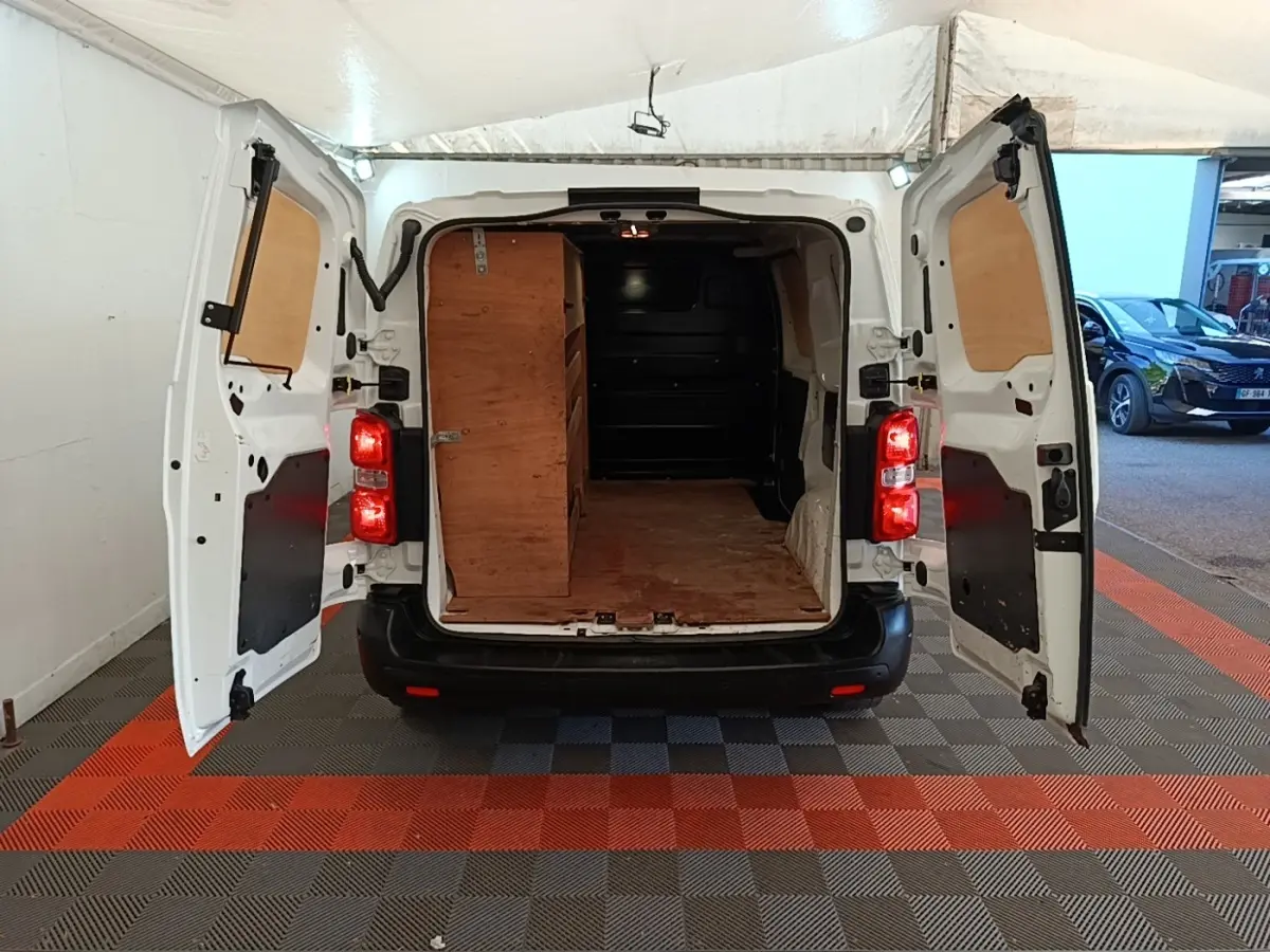 Vue arrière d'un Citroën Jumpy blanc 2021 avec portes ouvertes montrant l'espace de chargement en bois.