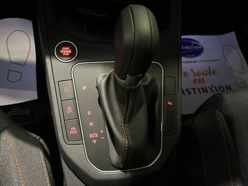 Le levier de vitesse automatique noir avec surpiqûres orange de la SEAT Ibiza 2024, vue rapprochée de la console centrale.