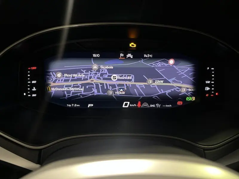 Tableau de bord numérique de la SEAT IBIZA 2024 avec affichage de navigation et voyants allumés en vue frontale.