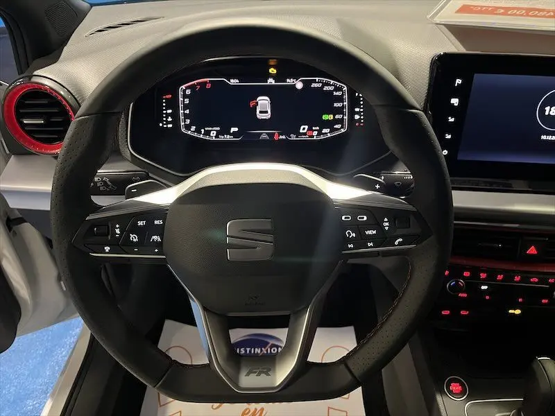 Vue rapprochée du volant multifonction noir avec logo SEAT et tableau de bord numérique de la SEAT Ibiza 2024.