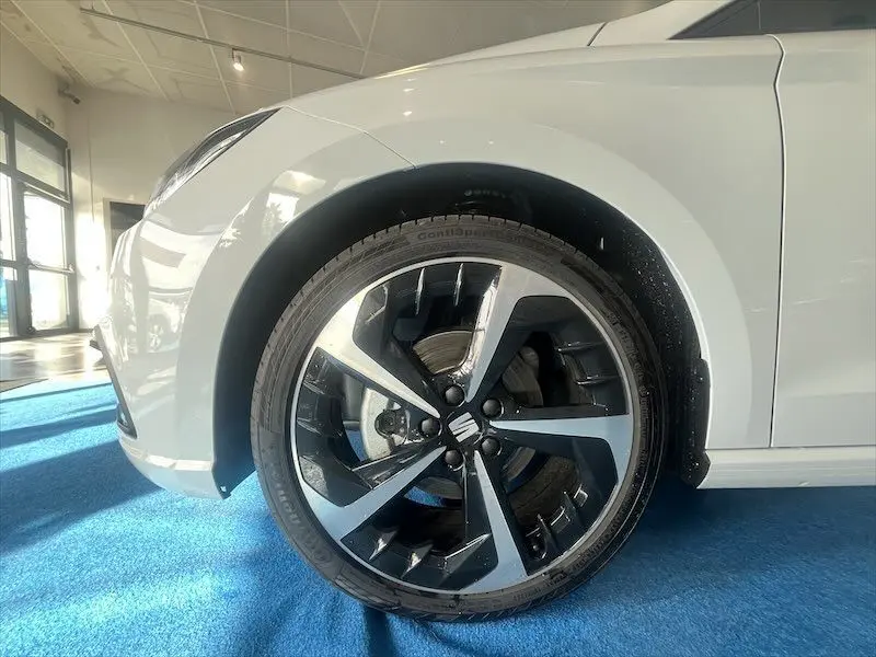 Gros plan sur la roue avant droite de la SEAT Ibiza blanc Nevada avec jante alliage bicolore et logo central visible.